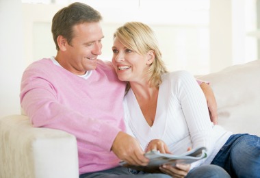 A mature couple relaxing together on a sofa at home