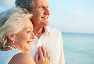 An older couple embracing by the sea
